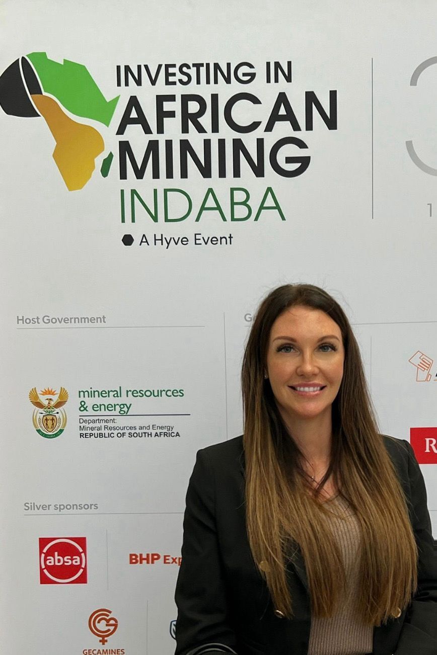 Image of Natalie Bellis infront of the investing in African mining indaba hype event sign