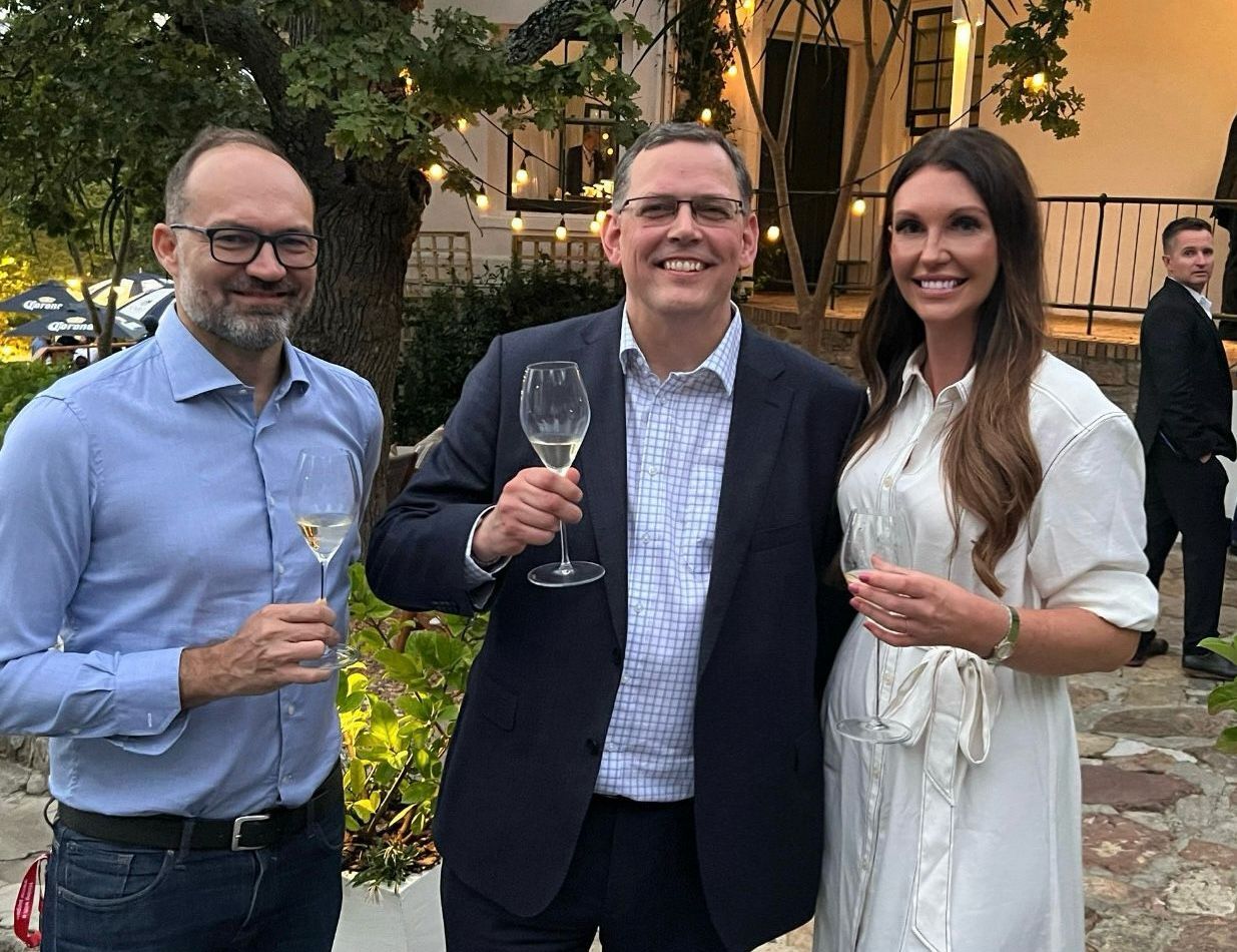 Image of Natalie Bellis with two men holding wine glasses
